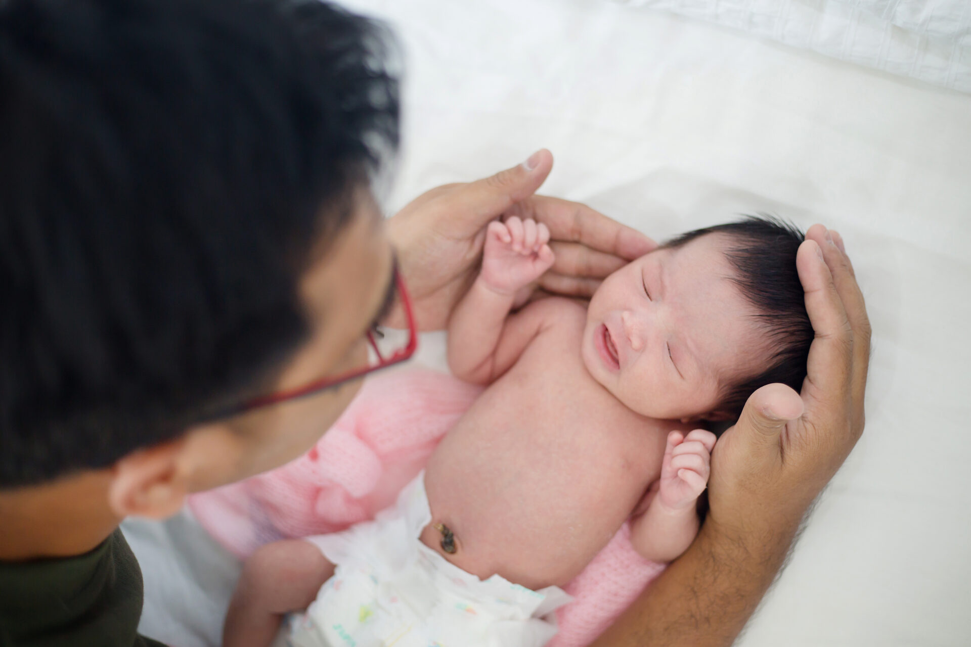 Asian father take care his adorable newborn baby carefully