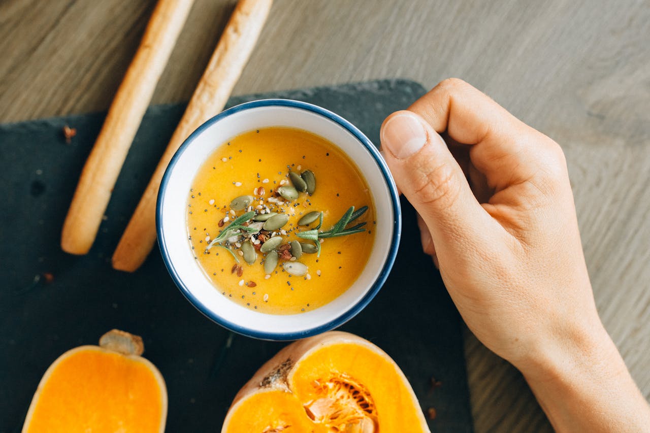 A hand holding a cup of soup 