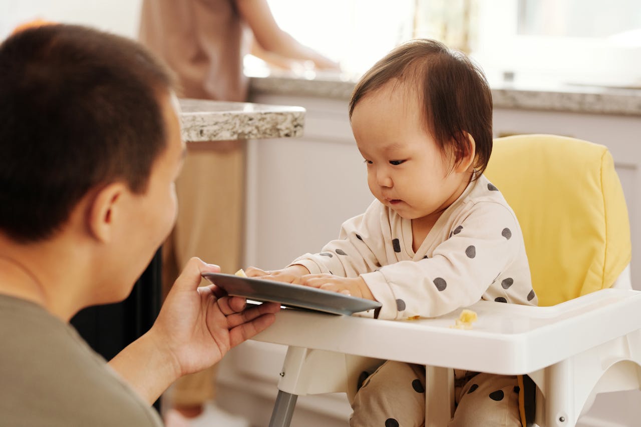 A person giving a baby food to his mother