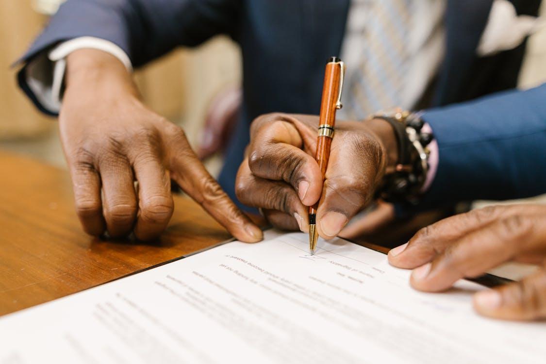 Free Close-Up Shot of a Person Writing on a Contract Stock Photo